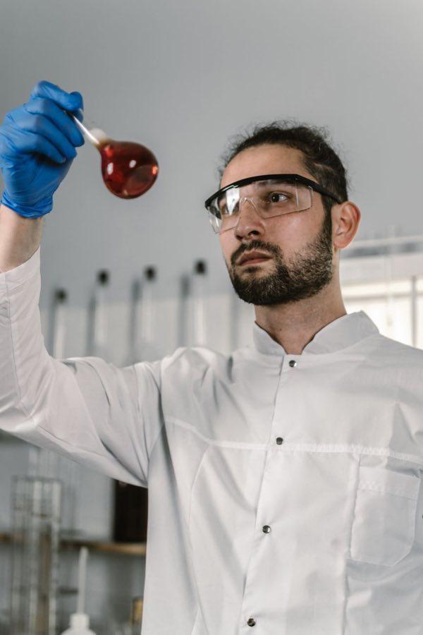 Scientist examining a flask of red solution
